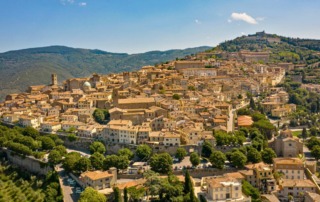 A stunning aerial shot of Cortona, Italy, displaying its historic architecture, narrow streets, and terracotta rooftops.