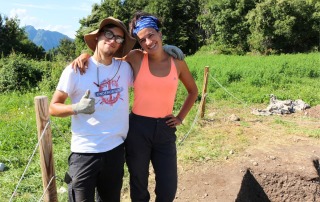 Two students smiling and posing for a group photo at an archaeological field school site in Vicenza, Italy, enjoying their fieldwork experience