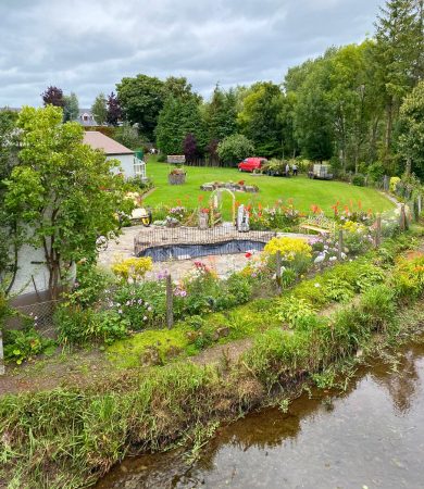 Beautiful garden in the town of Birr, Ireland, with vibrant flowers, greenery, and a serene pond, showcasing the charm of rural Irish landscapes