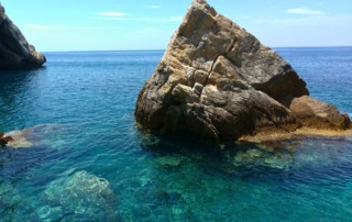 Crystal-clear waters surrounding the hidden chapel of Ekklisia Krifti, a local travel gem in Lesvos, Greece.