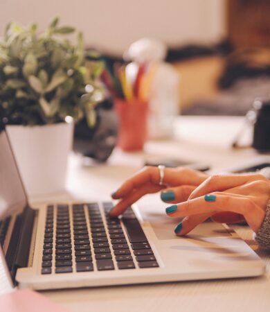 A close-up of hands typing on a laptop keyboard, symbolizing preparation for a field school application.