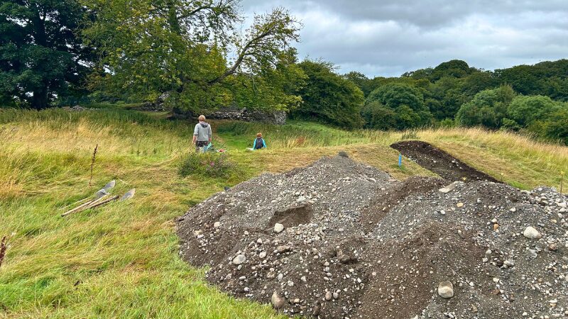 Clonoghill Castle archaeological field site in Ireland Clonoghill Castle excavation site in Ireland, with mounds of excavated soil and lush green surroundings.